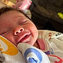 Kleo is registered to the contest to win money with this photo: baby, blanket, can, child, closeup, clothing, couch, cozy, face, furniture, head, indoor, infant, peaceful, person, relaxation, sleeping, smile, soft_lighting, table