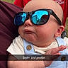 Jett joined the competition — help win amazing prizes! baby, sunglasses, adult, holding, outdoor, grass, red_shirt, reflection, hand, blue_overall, cute, portrait, child, person, face, fashion, casual, expression, snapchat, text_overlay