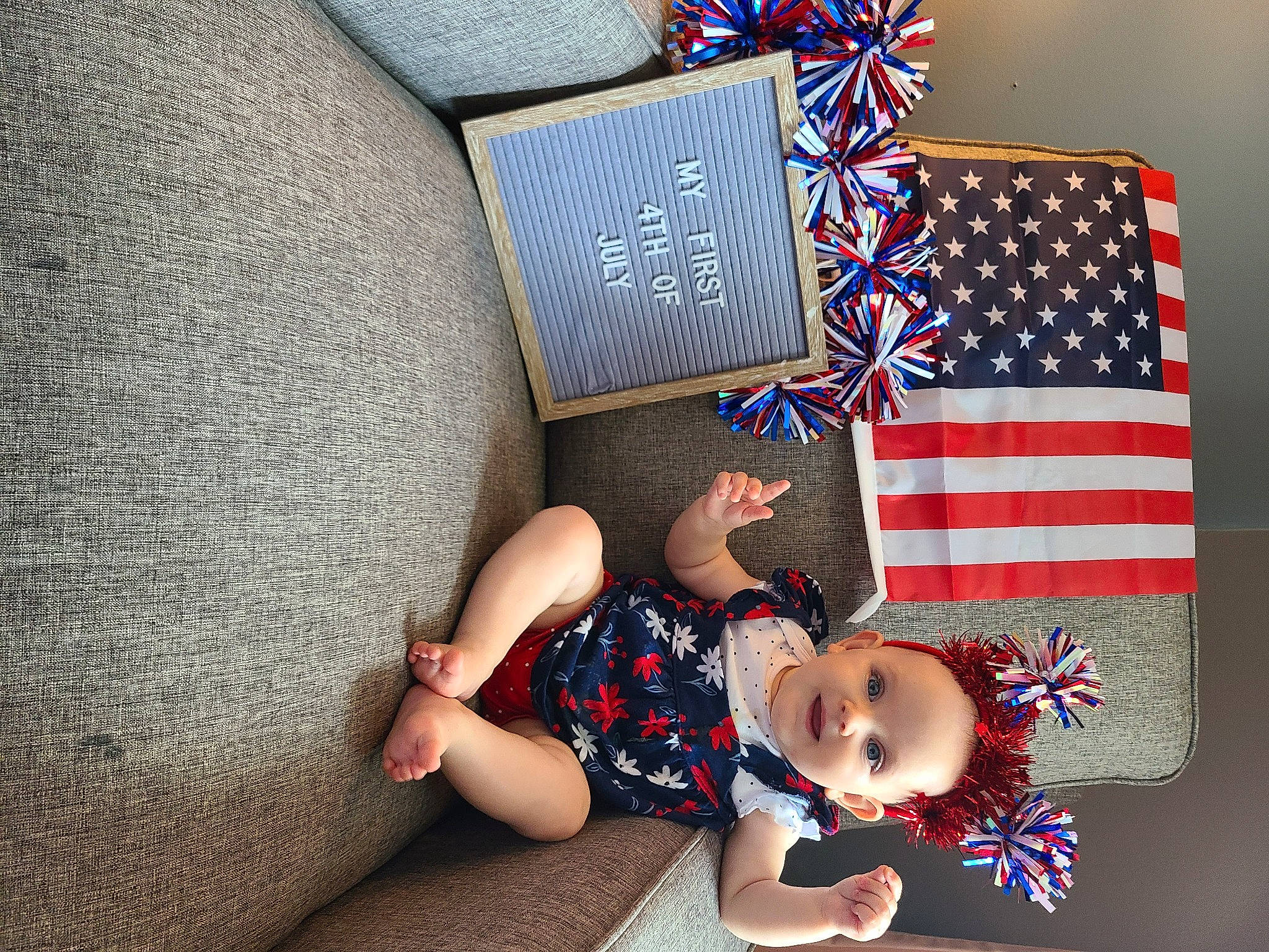 Rowan is registered to the contest to win money with this photo: baby_toddler_clothing, child, comfort, event, fashion_accessory, flag, flag_day_usa, flag_of_the_united_states, foot, fun, happy, hat, holiday, linens, pattern, person, room, sitting, sock, t_shirt