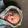 Colby is registered to the contest to win money with this photo: baby, child, face, hood, jacket, clothing, infant, portrait, cute, soft_texture, blue, eyes, skin, indoor, young, person, warm, expression, closeup, apparel