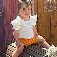 Dayana participe au concours pour gagner de l'argent avec cette photo : toddler, child, sitting, white_shirt, orange_shorts, pony_tail_hairstyle, bracelet, wooden_bench, outdoor, daylight, shoes, cute, serious_expression, portrait, person, fashion, summer, casual_clothing, young_child, hair_style
