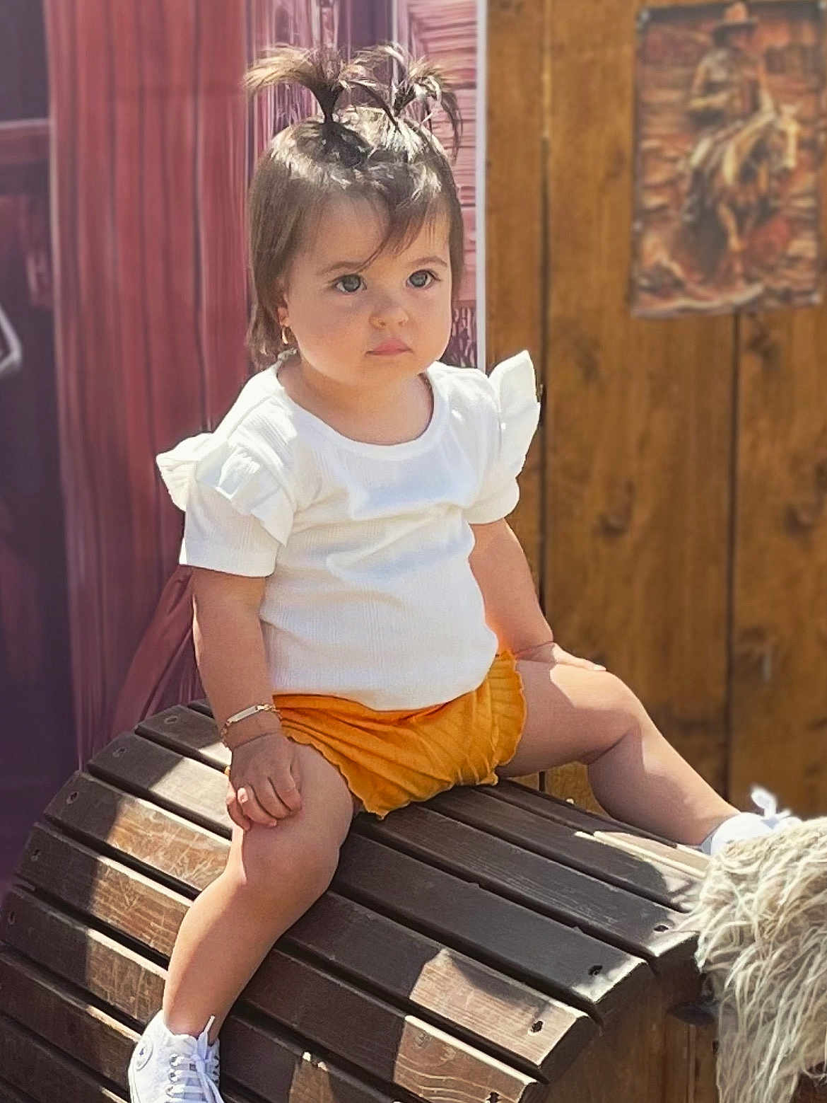 Dayana participe au concours pour gagner de l'argent avec cette photo : toddler, child, sitting, white_shirt, orange_shorts, pony_tail_hairstyle, bracelet, wooden_bench, outdoor, daylight, shoes, cute, serious_expression, portrait, person, fashion, summer, casual_clothing, young_child, hair_style