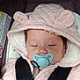 baby, pacifier, car_seat, pink_hood, bear_ears, black_straps, sleeping, infant, child, clothing, jacket, seatbelt, closeup, face, cute, child_safety, indoors, young_child, headwear, comfort