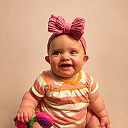 Willow is registered to the contest to win money with this photo: baby, bright_eyes, child, chubby_arms, chubby_legs, colorful, cute, happy, headband, indoor, infant, pink_bow, playful, portrait, sitting, smile, soft_background, striped_onesie, toy, young_child