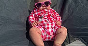 Willow is registered to the contest to win money with this photo: baby, beach, camping_chair, cherry_pattern, child, cute, fashion, feet, infant, legs, outdoor, portrait, red_and_white, relaxed, romper, sand, shade, summer, sunglasses, sunny