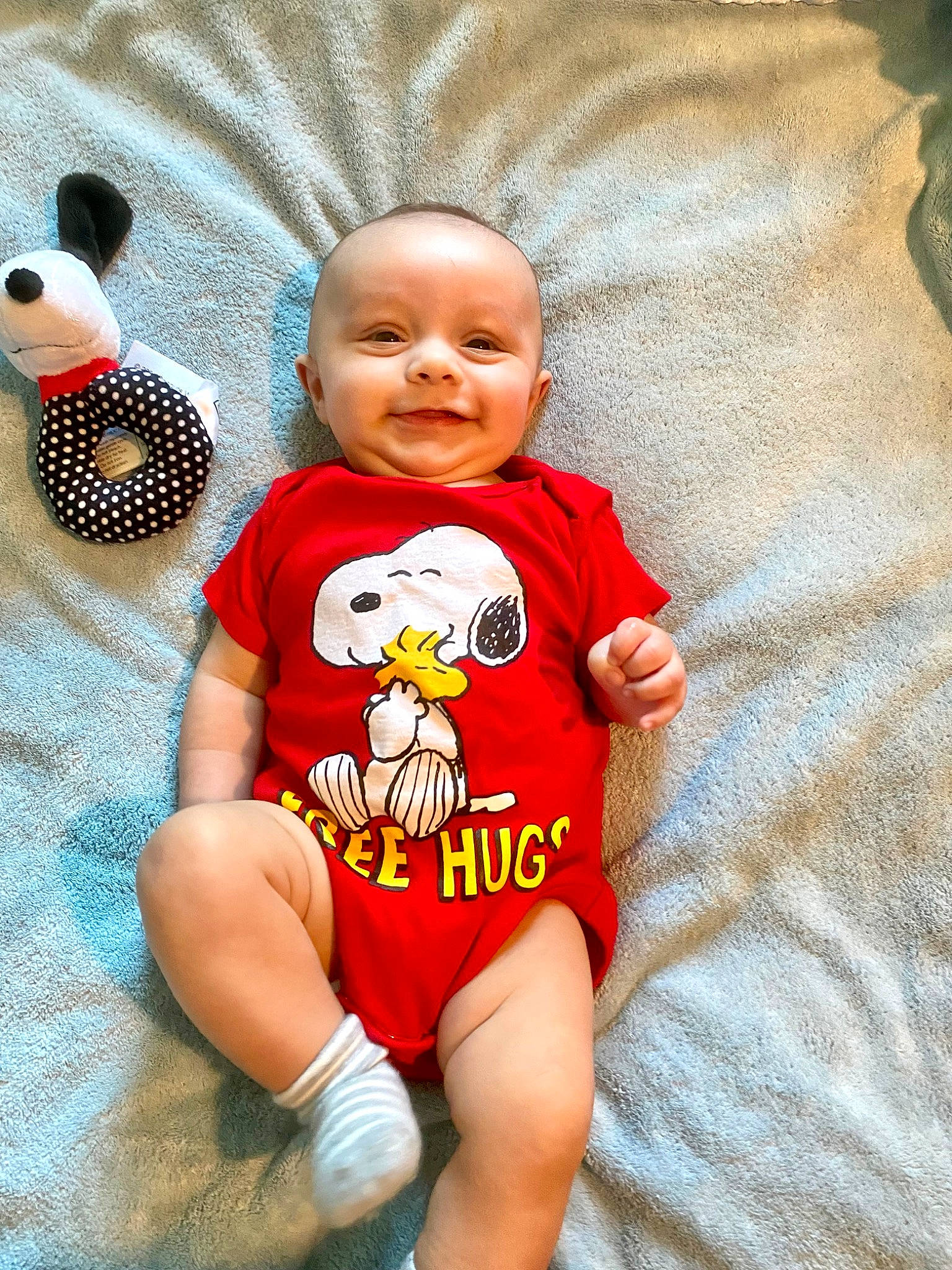 Bentley is registered to the contest to win money with this photo: baby, baby_products, baby_toddler_clothing, child, eye, facial_expression, finger, flooring, happy, joy, linens, pattern, person, play, product, sleeve, smile, stuffed_toy, t_shirt, toddler