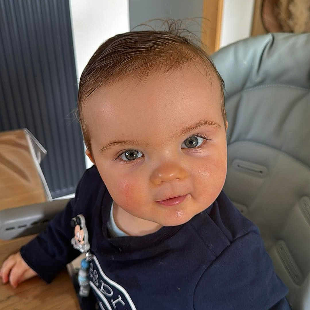 Leo participe au concours pour gagner de l'argent avec cette photo : architecture, baby, building, clothing, couch, door, face, furniture, head, indoors, interiordesign, livingroom, pants, person, photography, portrait, room, sitting, t_shirt, wood