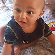 Hayden participe au concours pour gagner de l'argent avec cette photo : baby, child, infant, crawling, bed, bedding, pattern, blue_shirt, skin, face, eyes, hand, foot, indoors, cute, young, person, exploring, expression, soft_light