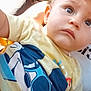baby, car_seat, casual_clothing, child, cute, expression, face, graphic_tshirt, hat, headwear, indoors, person, portrait, seat, shadow, sunlight, toddler, vehicle_interior, yellow_shirt, young_child