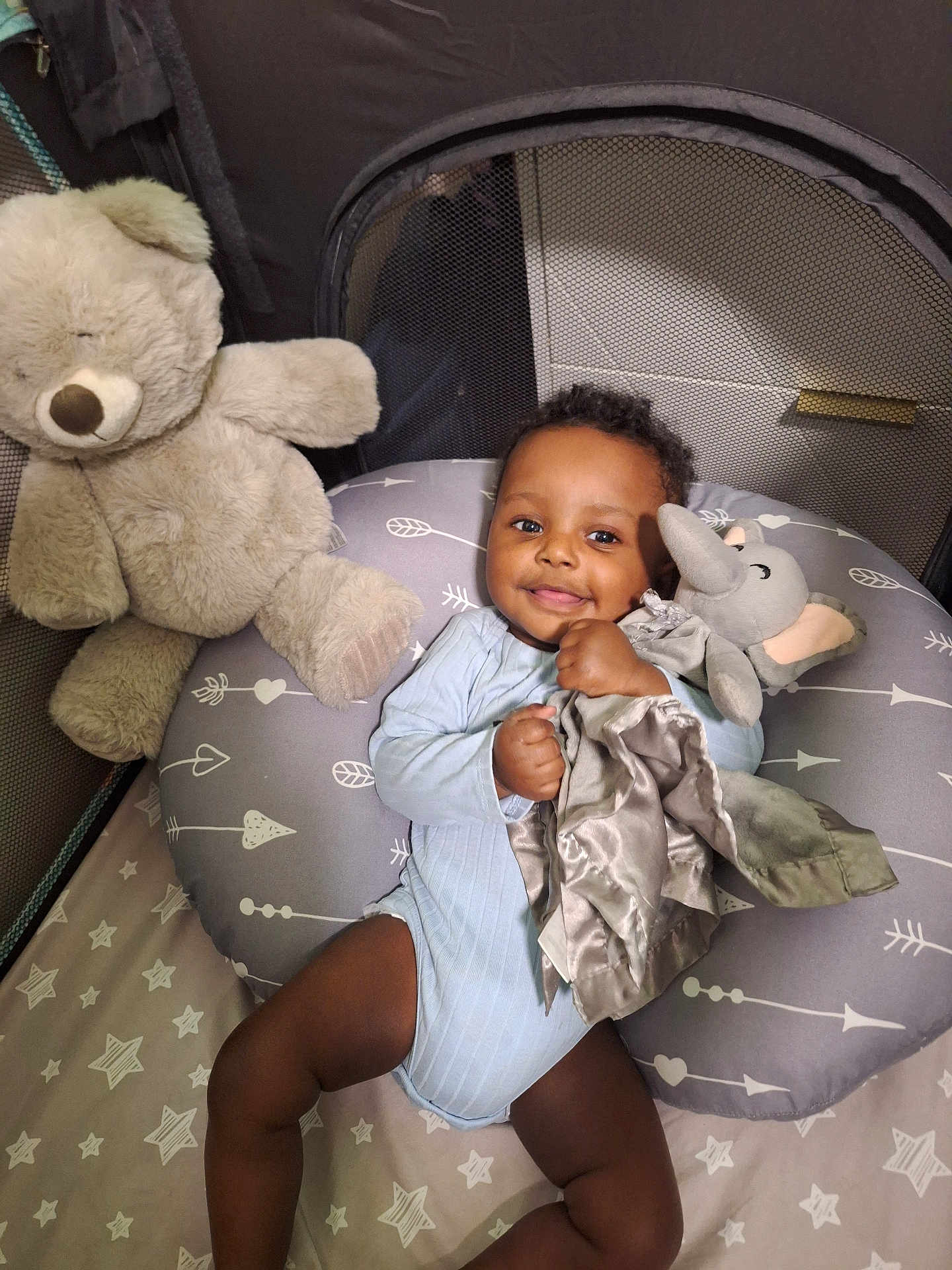 Sohan joined the competition — help win amazing prizes! baby, child, infant, teddy_bear, plush_toy, elephant_toy, pillow, bedding, stars_pattern, smiling, cute, indoor, person, sleeping_area, baby_clothing, baby_girl, baby_boy, resting, happy, cozy