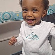 Sohan joined the competition — help win amazing prizes! toddler, child, smiling, happy, indoor, playpen, white_shirt, dinosaur_print, baby, cute, portrait, person, standing, young_child, clothing, home, infant, face, joyful, curious