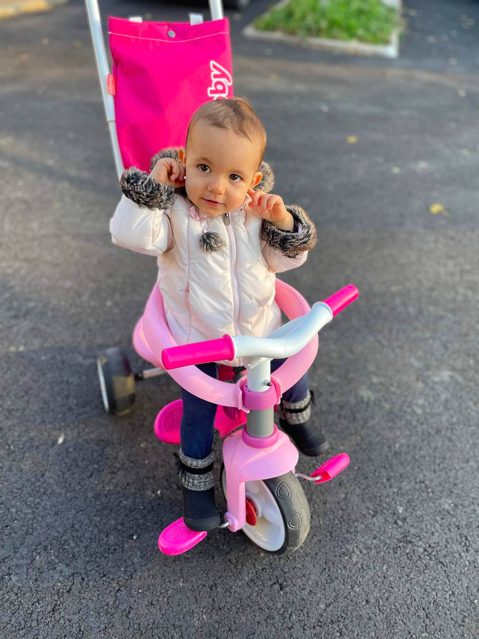 Camélia participe au concours pour gagner de l'argent avec cette photo : asphalt, baby_carriage, baby_products, child, fun, happy, magenta, person, pink, plant, public_space, purple, recreation, shoe, smile, sneakers, sock, tire, toddler, toy