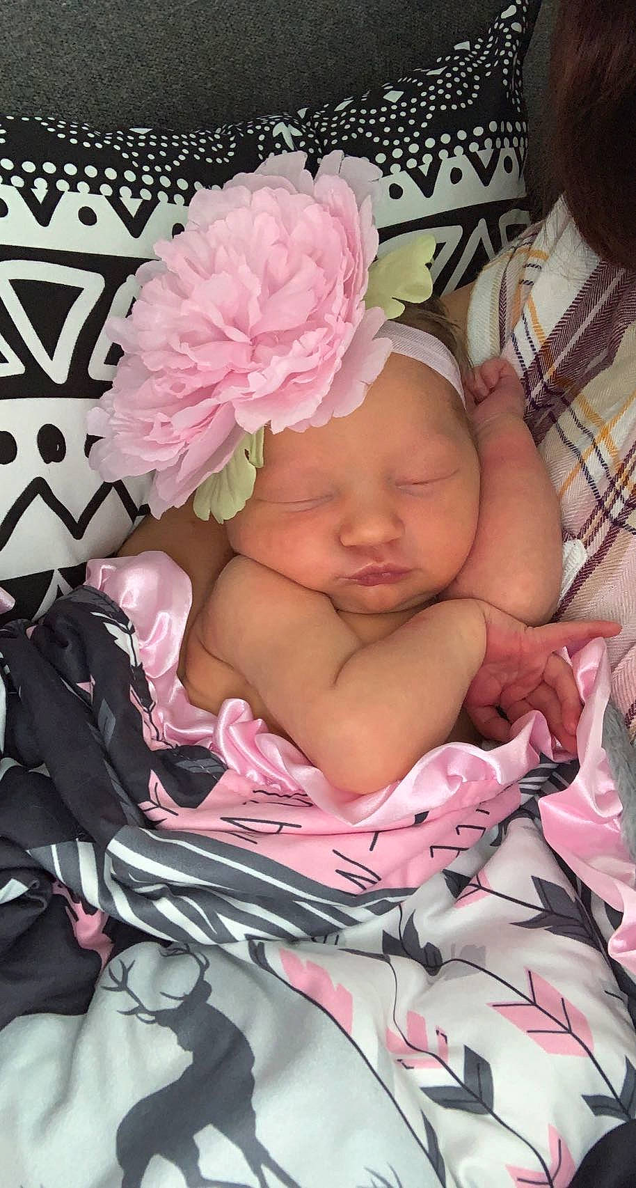 Ashlynn is registered to the contest to win money with this photo: baby, baby_products, baby_sleeping, baby_toddler_clothing, cheek, child, comfort, fashion_accessory, flower, headband, headpiece, headwear, linens, magenta, pattern, peach, person, petal, pink, rose_family