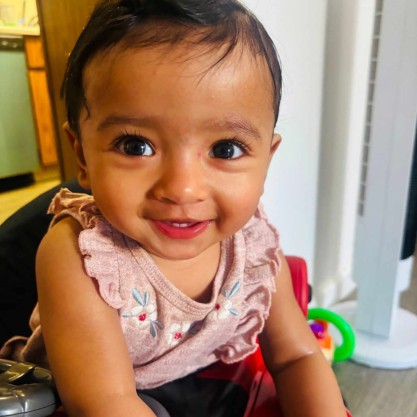 Yashna Kottu is registered to the contest to win money with this photo: toddler, child, smile, face, indoors, toy_car, pink_clothing, embroidery, happy, cute, ruffles, person, baby, playful, young_child, black_hair, closeup, bright_eyes, home, floor