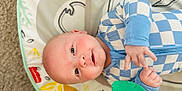 Beckham is registered to the contest to win money with this photo: baby, infant, child, lying_down, play_mat, toy, blue_clothing, checkered_pattern, happy, smiling, face, hand, carpet, indoor, cute, young_child, light_skin, head, eyes, playtime
