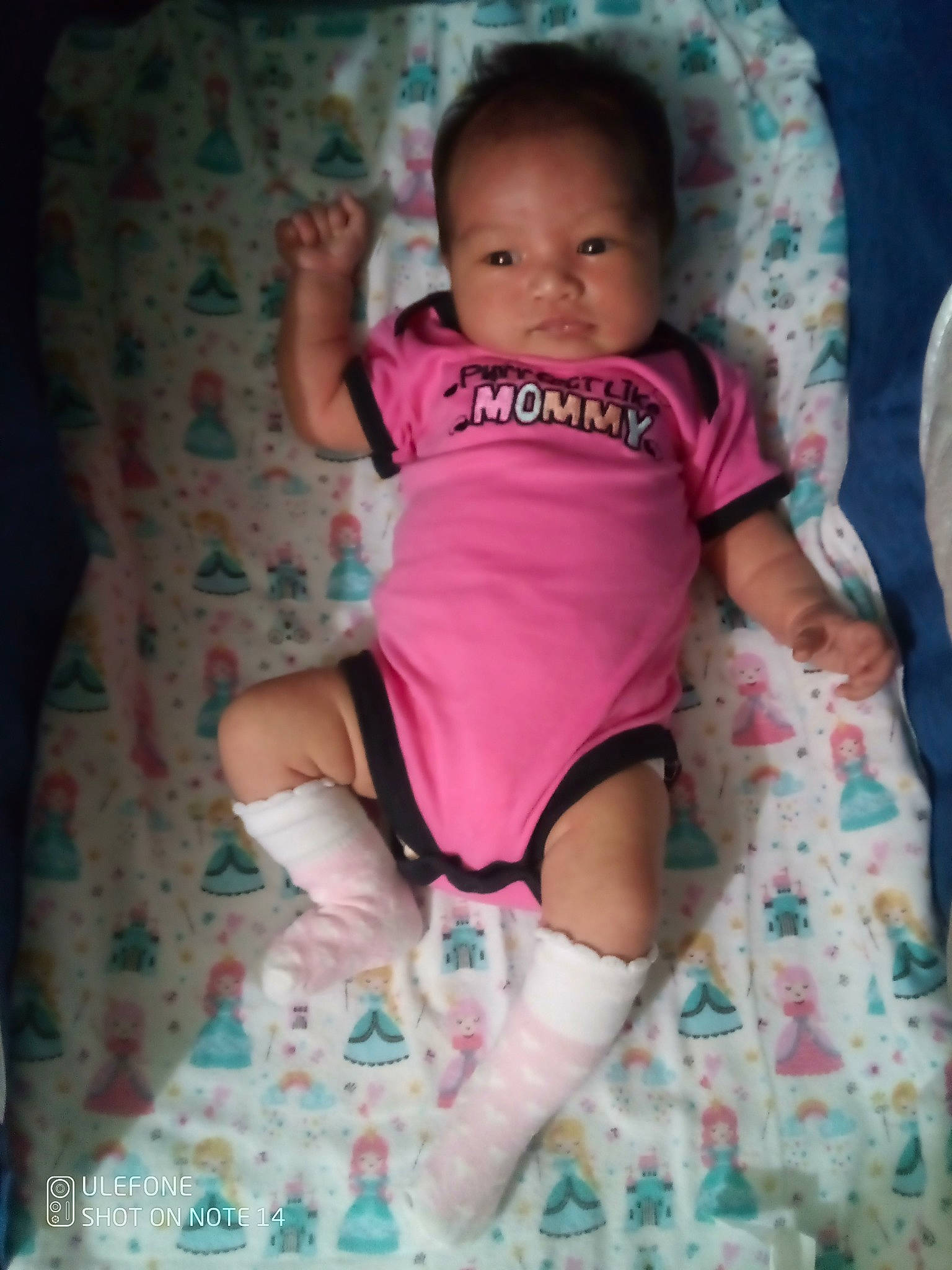 Vaianuanua participe au concours pour gagner de l'argent avec cette photo : baby, baby_toddler_clothing, comfort, eye, face, happy, head, human_body, knee, leg, mouth, neck, person, pink, skin, sleeve, t_shirt, thigh, thumb, toddler