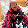 Tucker is registered to the contest to win money with this photo: baby, blanket, child, cozy, face, floor, giraffe_toy, hands, happy, home, indoor, pajamas, person, plaid, red_and_black, smile, socks, table, toy, wooden_floor