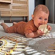 Andréa participe au concours pour gagner de l'argent avec cette photo : baby, infant, child, carpet, floor, wooden_toy, milestone_marker, orange_outfit, smiling, chewing, indoor, natural_light, wooden_furniture, cabinet, decor, happy, crawling, person, cozy, home
