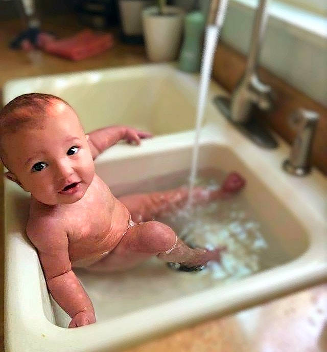 Lincoln Nicholas is registered to the contest to win money with this photo: baby, baby_bathing, baby_products, bath_toy, bathing, bathroom, bathtub, child, composite_material, fluid, fun, hand, person, plumbing, plumbing_fixture, sink, smile, tap, thumb, toddler