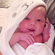 Presley is registered to the contest to win money with this photo: baby, infant, towel, hooded_towel, white_towel, cute, face, hand, skin, newborn, soft_texture, cozy, wrapped, portrait, indoor, child, expressive, pink_skin, looking, closeup