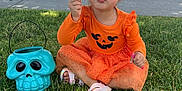 Aerith is registered to the contest to win money with this photo: toddler, child, grass, outdoor, orange_dress, halloween, skull_bucket, bubble_wand, playful, smiling, cute, sitting, daylight, suburban, tree, sidewalk, shoes, greenery, fun, holiday
