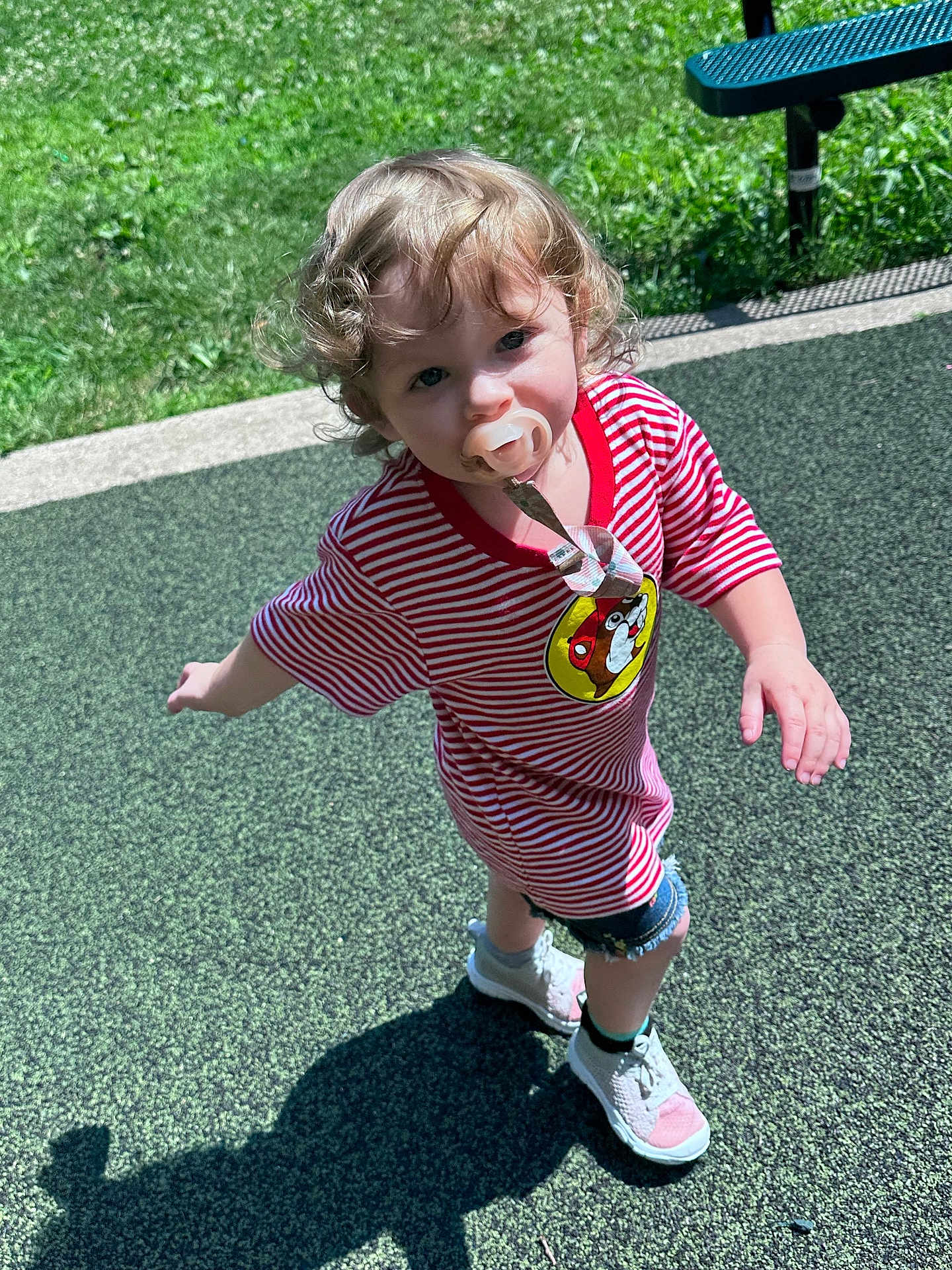 Mariana joined the competition — help win amazing prizes! toddler, child, pacifier, curly_hair, striped_shirt, denim_shorts, sneakers, outdoor, playground, grass, shadow, sunlight, walking, cute, summer, person, play, happy, kid, casual_clothing