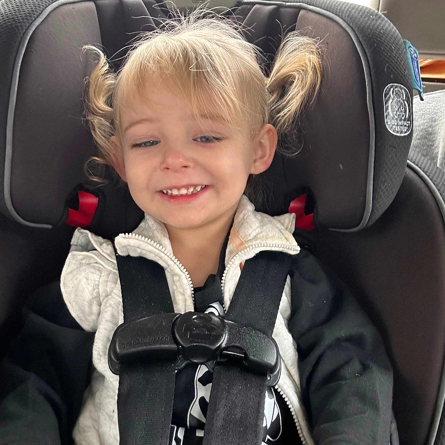 Lainey joined the competition — help win amazing prizes! baby, blonde_hair, car, car_interior, car_seat, casual_clothing, child, cute, happy, jacket, person, pigtails, portrait, safety, seat, seat_belt, smile, toddler, travel, young_child