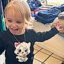 Lainey joined the competition — help win amazing prizes! child, toddler, blonde_hair, black_shirt, cartoon_print, playful, tongue_out, indoor, clothing, folded_clothes, window, car, tile_floor, necklace, cute, happy, person, smiling, long_sleeves, casual