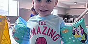 Zachariah joined the competition — help win amazing prizes! child, smiling, indoor, pool, goggles, floaties, swimwear, wet_hair, spiderman, shirt, red_shorts, caution_sign, tiles, person, water, cartoon, playful, happy, recreation, swimming_pool