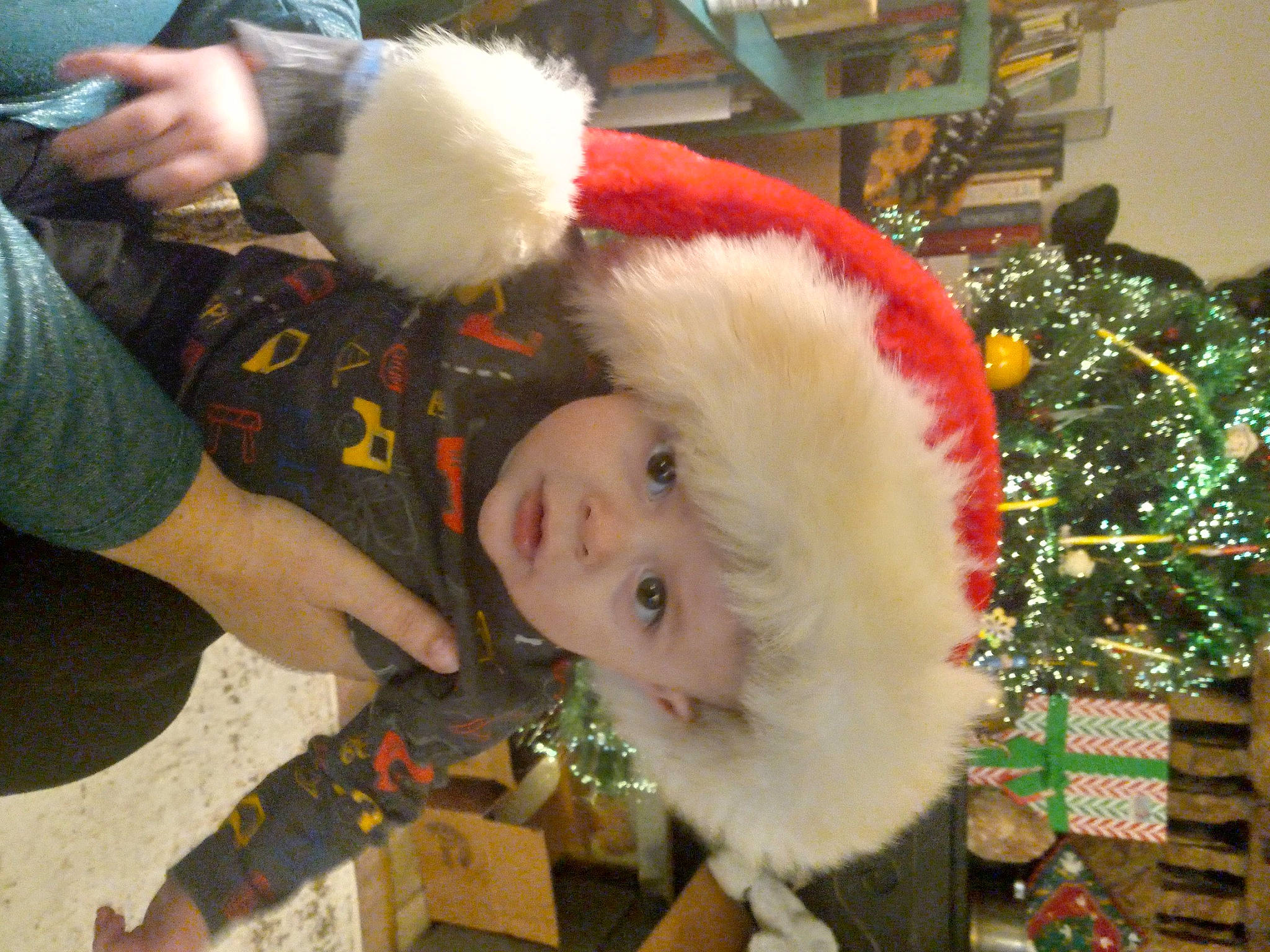 Izaiah joined the competition — help win amazing prizes! baby, christmas, christmas_decoration, christmas_eve, christmas_ornament, christmas_tree, conifer, event, fictional_character, fun, fur, fur_clothing, happy, hat, headwear, holiday, lap, person, santa_claus, smile