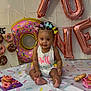 baby, child, donuts, balloons, birthday, celebration, smiling, hair_bows, sitting, colorful, decorations, sprinkles, food, party, infant, festive, floor, cloth, portrait, cute