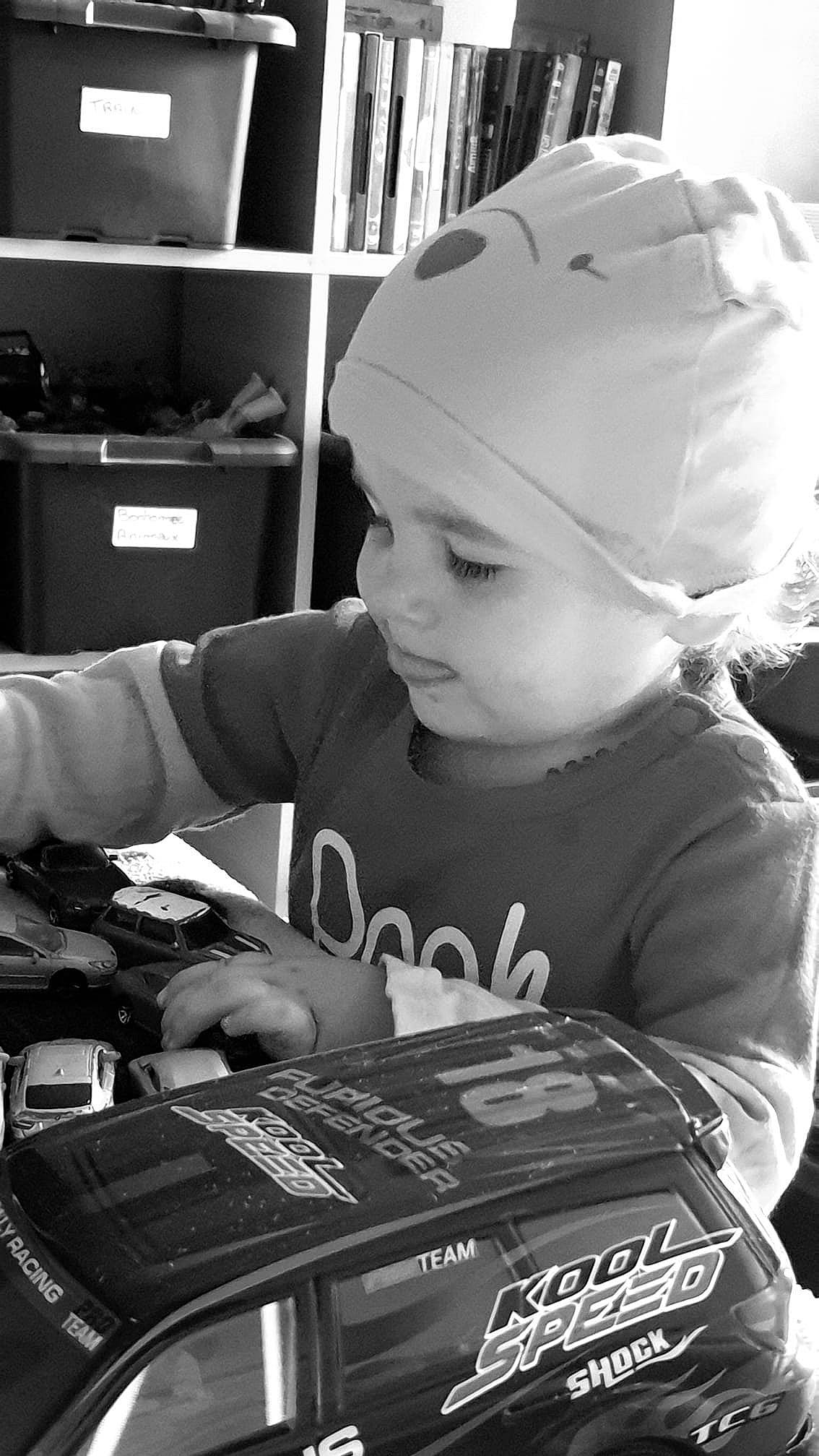 Ange participe au concours pour gagner de l'argent avec cette photo : audio_equipment, baby, black, black_and_white, cap, child, cool, electronic_instrument, fun, gadget, hairstyle, happy, headwear, monochrome, monochrome_photography, people, person, shelf, sitting, style