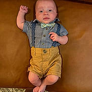 Ledger joined the competition — help win amazing prizes! baby, child, infant, bow_tie, suspenders, shorts, shirt, leather_couch, footwear, barefoot, person, portrait, indoor, curious, cute, fashion, legs, carpet, raised_fist, blue_shirt