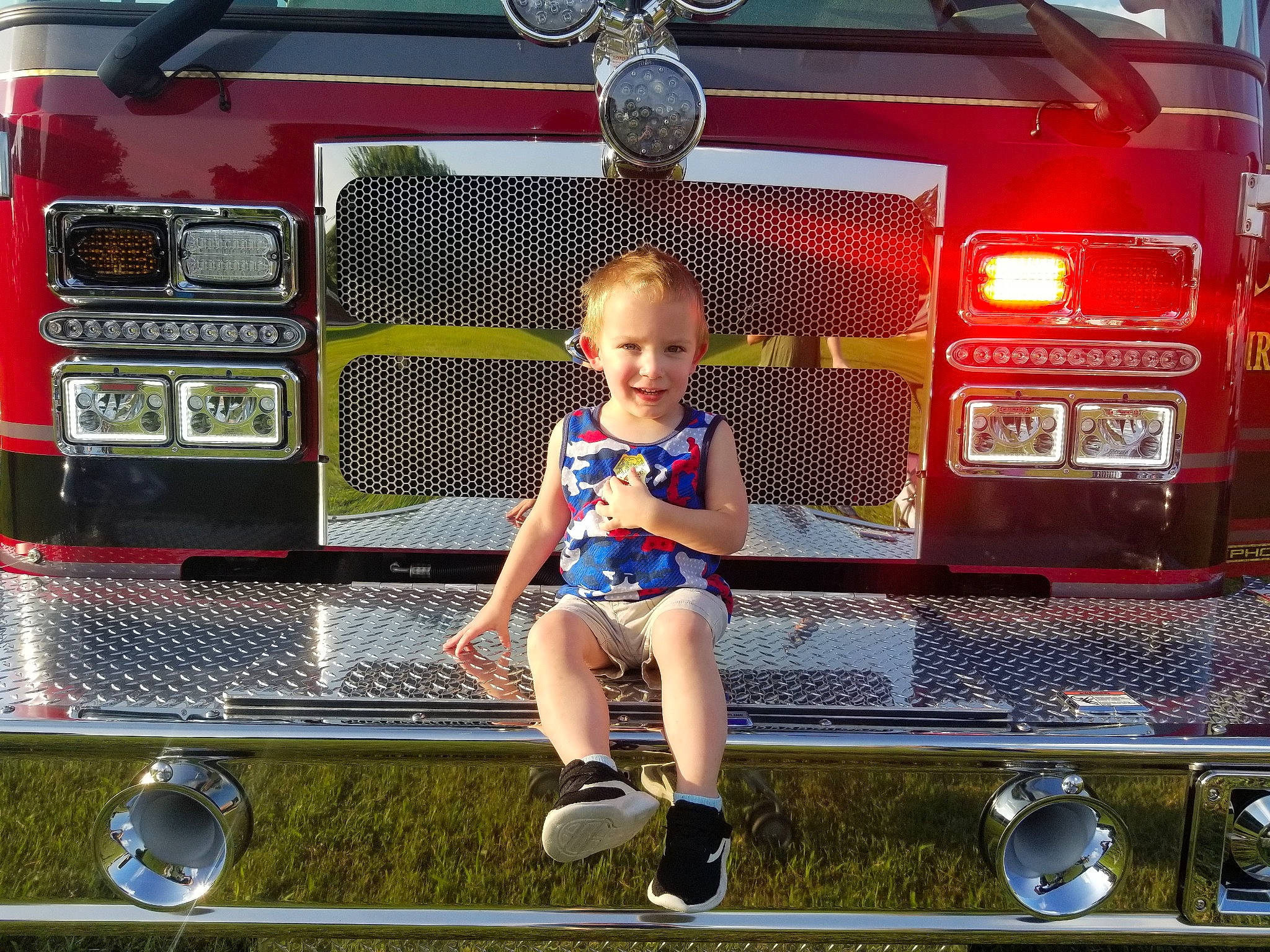 Liam is registered to the contest to win money with this photo: automotive_design, automotive_exterior, automotive_fog_light, automotive_lighting, automotive_tail_brake_light, automotive_tire, automotive_wheel_system, bumper, car, fender, grille, hood, joy, light, motor_vehicle, person, shoe, shorts, smile, sneakers