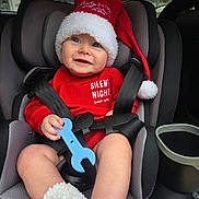 Everhett joined the competition — help win amazing prizes! baby, car_seat, child, smiling, red_clothing, santa_hat, toy, blue_toy, winter_clothing, cozy_booties, face, person, seatbelt, indoor, car_interior, happy, holiday, festive, cute, infant