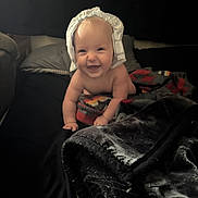 Maelynn joined the competition — help win amazing prizes! baby, bed, blanket, child, comfort, crawling, cute, expression, face, happy, headwear, indoors, infant, person, playful, portrait, smiling, soft_texture, warm, young