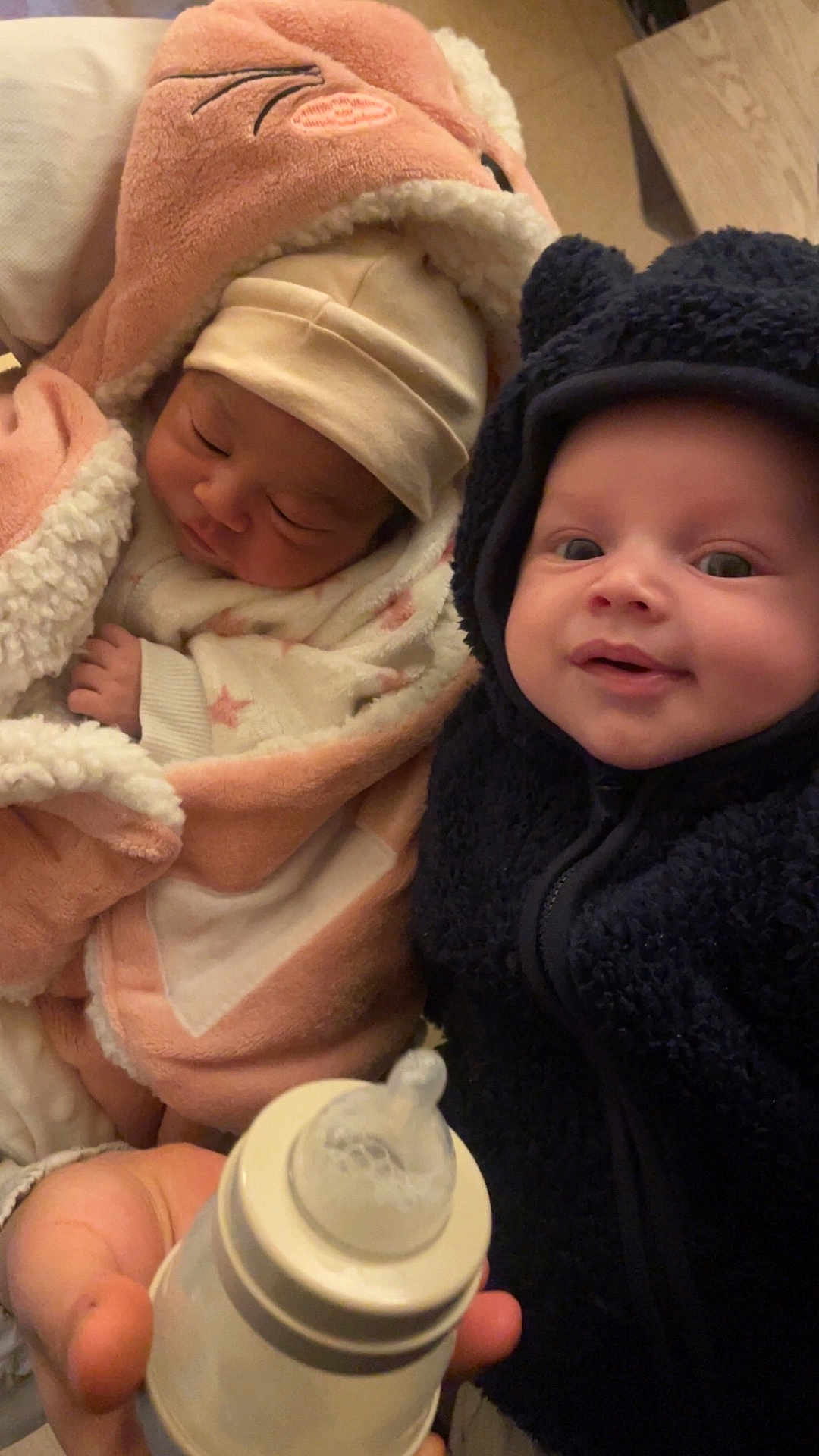 Ilyane a rejoint le concours — aidez-le/la à gagner de superbes lots ! baby, infant, child, blanket, hoodie, bottle, milk_bottle, sleeping, smiling, face, hand, cozy, warm_clothing, indoor, person, cute, newborn, soft_texture, toddler, portrait