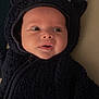 Ilyane participe au concours pour gagner de l'argent avec cette photo : baby, infant, child, face, costume, hood, ears, black, fur, clothing, cute, portrait, expression, lying_down, indoors, soft, warm, apparel, young, person