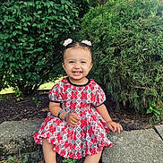 Subella is registered to the contest to win money with this photo: toddler, child, smiling, dress, outdoor, greenery, bush, tree, sandals, hair_accessories, stone, nature, happy, cute, anklet, sitting, sunlight, playful, garden, portrait