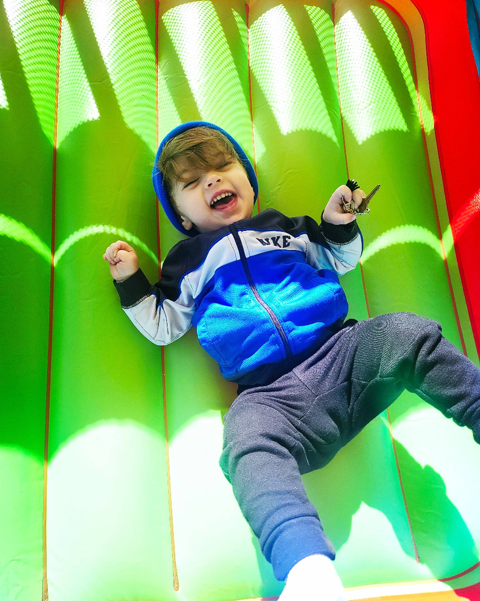 Leonidas is registered to the contest to win money with this photo: baby, baby_toddler_clothing, bounce_house, child, comfort, electric_blue, fun, grass, green, happy, leisure, outdoor_play_equipment, person, play, playground, recreation, sitting, smile, thigh, toddler