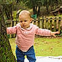 toddler, child, tree, outdoor, nature, grass, blanket, pink_sweater, jeans, shoes, moss, fence, forest, standing, balance, person, young_child, casual_clothing, daylight, curious