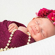 Maddie a rejoint le concours — aidez-le/la à gagner de superbes lots ! baby, sleeping, blanket, maroon, headband, flowers, pearl_necklace, hand, closeup, soft_texture, white_background, infant, peaceful, portrait, resting, cute, newborn, cozy, wrapped, adorable