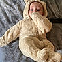 baby, bear_costume, blanket, child, cozy, cuddly, cute, fluffy, headwear, indoor, infant, lying_down, onesie, person, portrait, sleepwear, soft_texture, thumb_sucking, warm, young_child