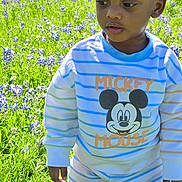 Braylon joined the competition — help win amazing prizes! child, boy, outdoor, field, grass, flowers, purple_flowers, striped_clothing, mickey_mouse, cartoon_character, sunlight, nature, portrait, casual_wear, young_child, greenery, daylight, person, standing, curious