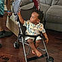 Braylon joined the competition — help win amazing prizes! toddler, child, stroller, indoor, wooden_floor, couch, curious, looking_up, shark_canopy, colorful_clothing, adult_hand, footwear, casual, home_interior, playful, seated, baby, person, furniture, living_room