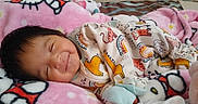 Destiny is registered to the contest to win money with this photo: baby, smiling, sleeping, blanket, pink, onesie, animal_print, cute, child, infant, cozy, soft, face, portrait, bed, comfort, happy, indoors, resting, toddler
