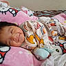 baby, smiling, sleeping, blanket, pink, onesie, animal_print, cute, child, infant, cozy, soft, face, portrait, bed, comfort, happy, indoors, resting, toddler