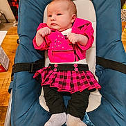 Elena a rejoint le concours — aidez-le/la à gagner de superbes lots ! baby, infant, child, pink_jacket, plaid_skirt, black_leggings, gray_socks, baby_seat, blue_cushion, indoor, wooden_table, curious_expression, clothing, seated, small_hands, cute, young_child, face, person, portrait
