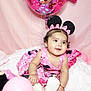 Laylah is registered to the contest to win money with this photo: baby, child, pink, balloon, minnie_mouse, dress, headband, mouse_ears, smile, fluffy_blanket, celebration, cute, indoor, toy, happy, birthday, accessory, sitting, infant, party