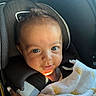 Sebastian is registered to the contest to win money with this photo: baby, child, car_seat, blanket, sunlight, smile, face, hand, seatbelt, portrait, infant, person, indoors, cute, cozy, clothing, headrest, bright_eyes, happy, young